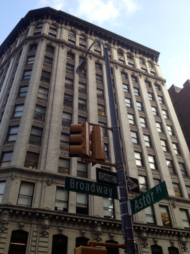 Fassade des Bürogebäudes an der Kreuzung Broadway / Astor Place in New York; im sechsten Stock befindet sich seit 1986 die Harvey-Milk-School für LGBTQIA-Jugendliche. Im Vordergrund Ampel und Straßenschilder.